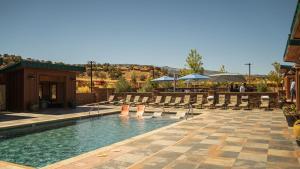 a swimming pool with chairs and a patio at Cougar Ridge Resort in Torrey