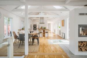 a dining room and kitchen with a table and chairs at Villa Kvarnbacken in Ljungbyholm