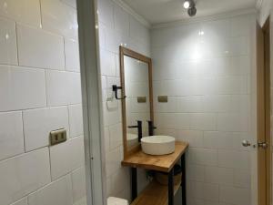 a bathroom with a sink and a mirror at Magnolia Mini House Casa A in Puerto Natales