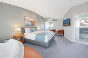 a hotel room with a bed and a bathroom at Waves Luxury Suites & Port Central Apartments in Port Campbell