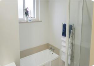 a white bathroom with a sink and a window at Stylish Tawa Retreat in Wellington +12 photos