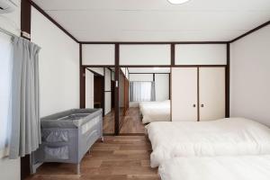 a bedroom with three beds and a mirror at Oyadoya江南名古屋まで車で40分Free car space2台 in Kōnan