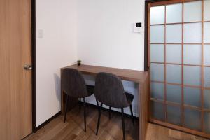 a small table with two chairs next to a door at Oyadoya江南名古屋まで車で40分Free car space2台 in Kōnan