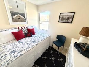 a bedroom with a bed and a blue chair at Birdsong Beachfront Condo in St. Pete Beach +38 photos