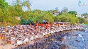 a group of people sitting on a pier next to the water at Camia Resort & Spa in Phú Quốc