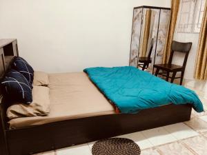 a bed with a blue blanket on it in a room at Tulip - Shillong in Shillong