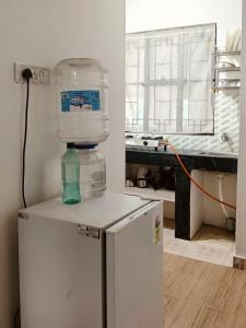 a refrigerator with a water bottle on top of it at Tulip - Shillong in Shillong