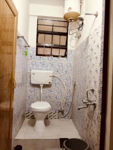 a small bathroom with a toilet and a shower at Tulip - Shillong in Shillong