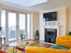 a living room with a yellow couch and a fireplace at Ailsa Craig View in Stranraer