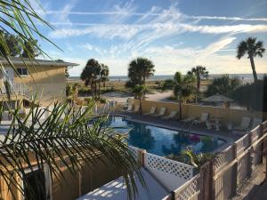 a swimming pool with a view of the beach at Birdsong Beachfront Condo in St. Pete Beach