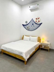 a bed in a room with a sign on the wall at Homestay Đan Sam in Ninh Hải