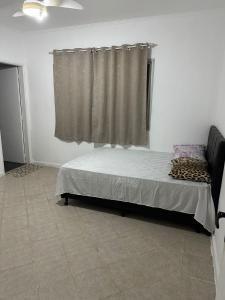 a bedroom with a bed and a window in a room at KITNET mobiliada com ar condicionado in Guarujá