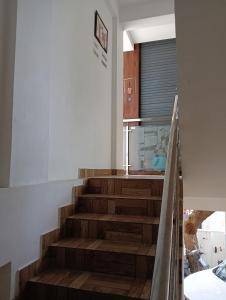 a staircase in a house with a kitchen at Orchid Woods Room in Trivandrum +1 photo