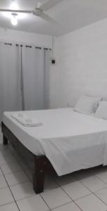 ein großes weißes Bett in einem Zimmer mit einer Decke in der Unterkunft Uncle Ben's in Apia