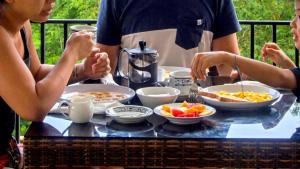 a group of people sitting around a table with food at Hotel Bonne Nuit in Labuan Bajo