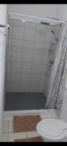 ein Badezimmer mit Dusche, Toilette und Waschbecken in der Unterkunft Uncle Ben's in Apia