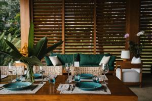 a wooden table with plates and wine glasses on it at Sanglung Villas & Suites in Kubutambahan +17 photos