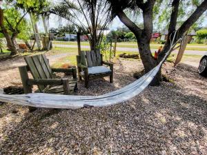 two chairs and a hammock under a tree at Reina Mar Jacuzzi Exclusivo in Barra de Portezuelo