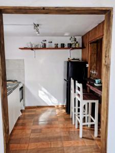 a kitchen with a table and chairs and a black refrigerator at Reina Mar Jacuzzi Exclusivo in Barra de Portezuelo