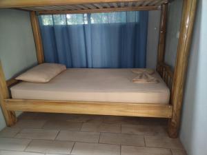 a bed with a wooden frame in a room at Jazlyn Lodge in Paquera