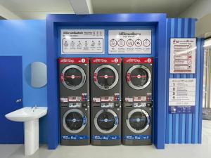 a room with four washing machines and a sink at V Style Pattaya North Beach in Pattaya