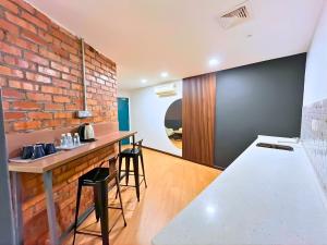 a kitchen with a brick wall and a counter with stools at Sky Hotel Cheras Maluri in Kuala Lumpur +36 photos
