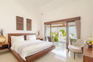 a bedroom with a large bed and a chair at Villa Leelavadee in Uluwatu +35 photos