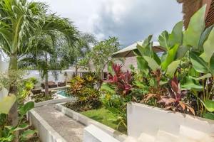 a garden with a swimming pool in a resort at Villa Leelavadee in Uluwatu
