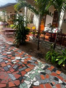 a stone walkway with palm trees in front of a building at Homsetay Đồng Phát in Ấp Thiện Phước