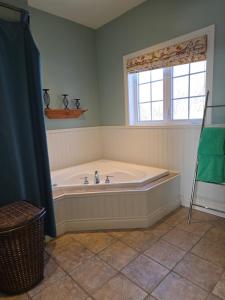 a bath tub in a bathroom with a window at Domaine des sentiers in Mansonville +74 photos