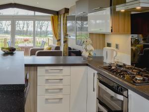 a kitchen with white cabinets and a stove top oven at Skylark Lodge in Westward +5 photos