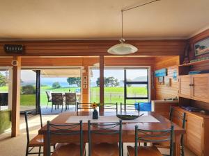 a kitchen and dining room with a table and chairs at Hahei Beachside Escape in Hahei