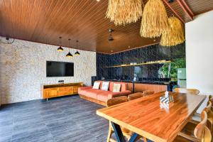 a living room with a wooden table and a couch at Arch Penida by Bali Cabin in Nusa Penida