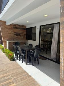 a patio with a table and chairs on it at Bangalô Camboinha triplex in Cabedelo