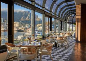 a restaurant with tables and chairs and a view of the city at InterContinental Table Bay Cape Town by IHG in Cape Town