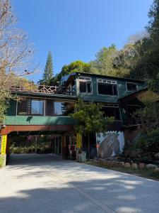 a large green building on top of a road at 木木杉民宿 in Puli