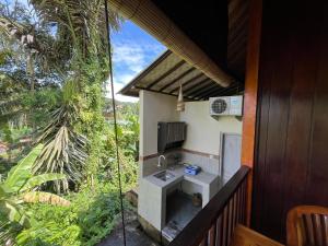 a bathroom with a sink and a tv on a balcony at Khrisna Hs and Cottages in Sidemen