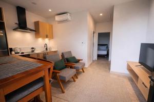 a room with a kitchen and a living room with chairs at Guest Space Fiji - Port Denarau Apts in Denarau