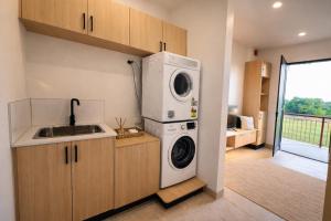 a kitchen with a washing machine and a sink at Guest Space Fiji - Port Denarau Apts in Denarau