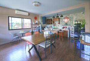 a kitchen and dining room with a table and chairs at V Tharm Hotel in Udon Thani