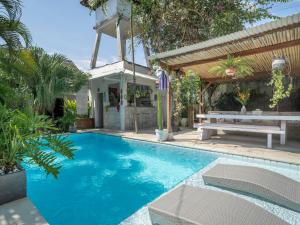 a swimming pool with a picnic table and a bench at Lila Boutik Canggu in Canggu +31 photos