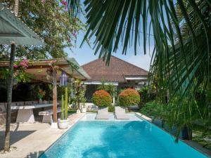a swimming pool in front of a house at Lila Boutik Canggu in Canggu