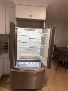 an empty refrigerator with its door open in a kitchen at Chic & Comfy Apartment in Elizabethport