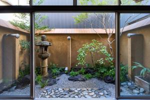 a garden with a water fountain in front of a building at Hotel Zen in Kyoto +19 photos