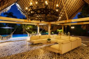 a living room with couches and a chandelier at Finca Los Mangos in Doradal