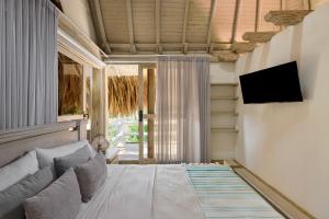 a bedroom with a bed and a tv on a wall at Finca Los Mangos in Doradal