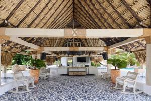 an open pavilion with chairs and a television in a resort lobby at Finca Los Mangos in Doradal