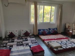 two beds sitting in a room with a window at Siva Rama garden resort 6 AC Bed rooms ,swimming pool ,BoX cricket ,Born fair,BBQ, kichan&all, near beach road bheemilli vishakapatnam in Visakhapatnam +177 photos
