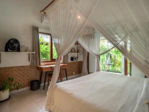 a bedroom with a bed with a desk and a window at Lila Boutik Canggu in Canggu