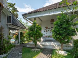 a home with a patio and trees in the yard at Lila Boutik Canggu in Canggu